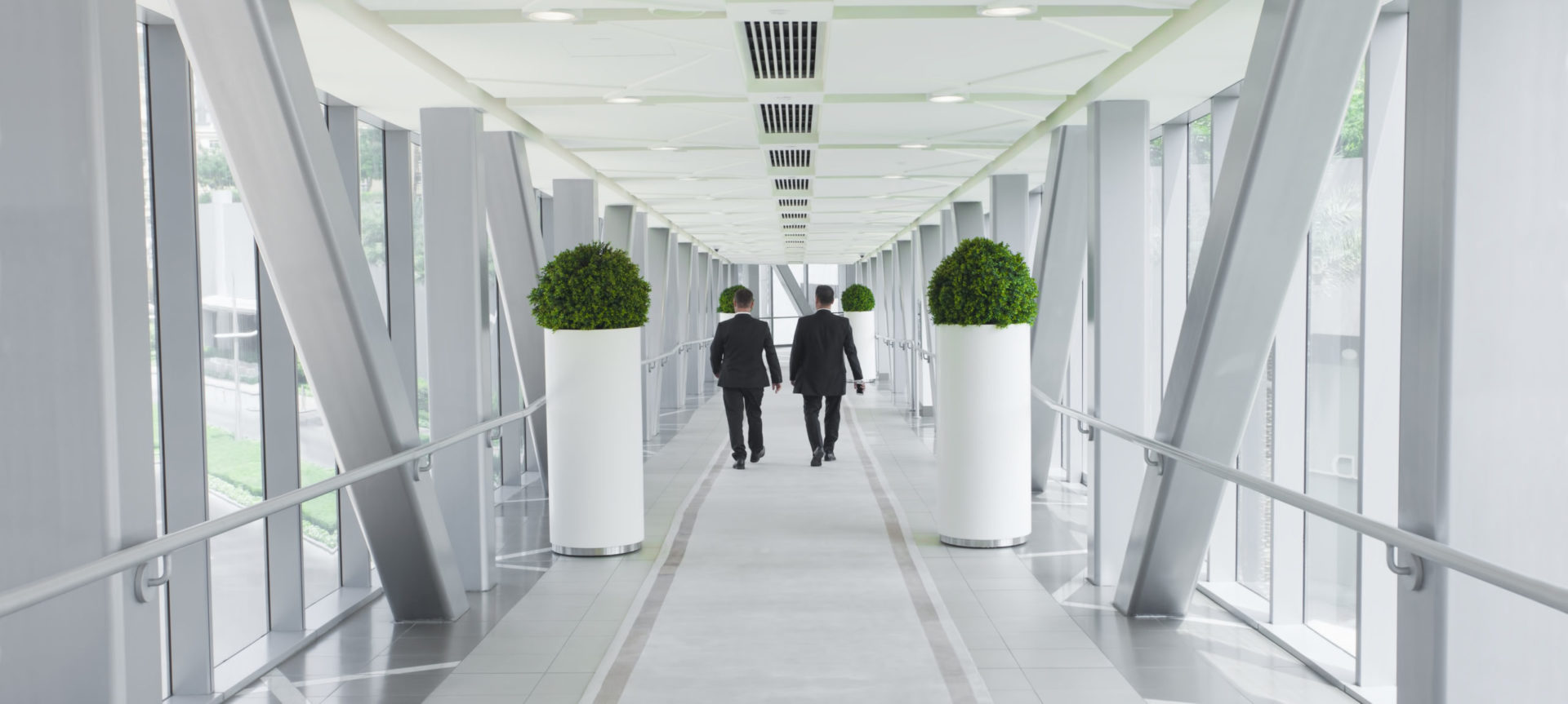 two business people walking in modern building, vision or su